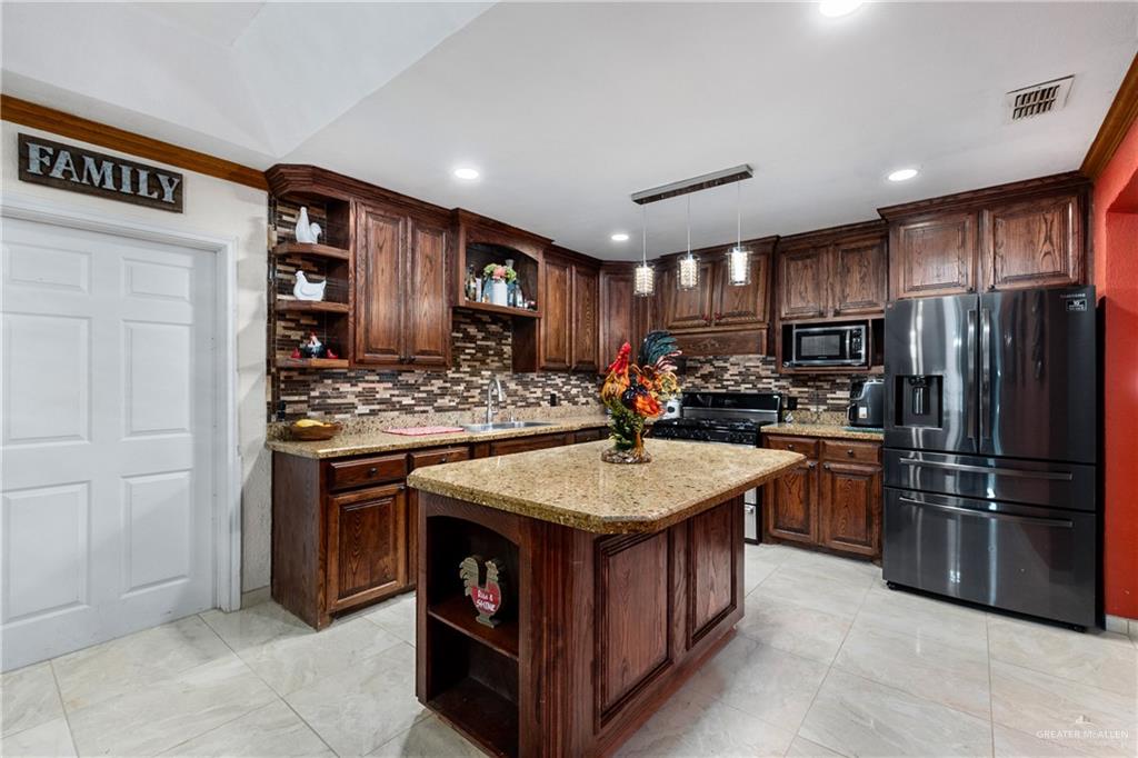 118 J R Becerra Avenue Progreso, TX 78596 - Photo 5 of 17 a kitchen with stainless steel appliances granite countertop a sink stove and refrigerator