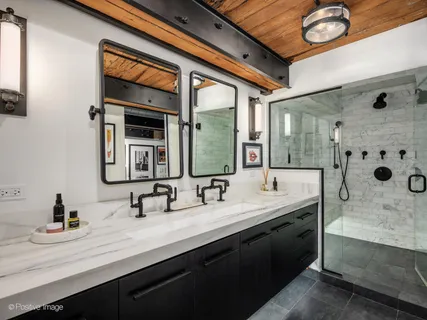 a bathroom with a double vanity sink mirror and bathtub