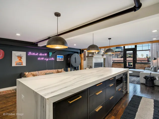 a kitchen with stainless steel appliances kitchen island granite countertop a table and chairs in it