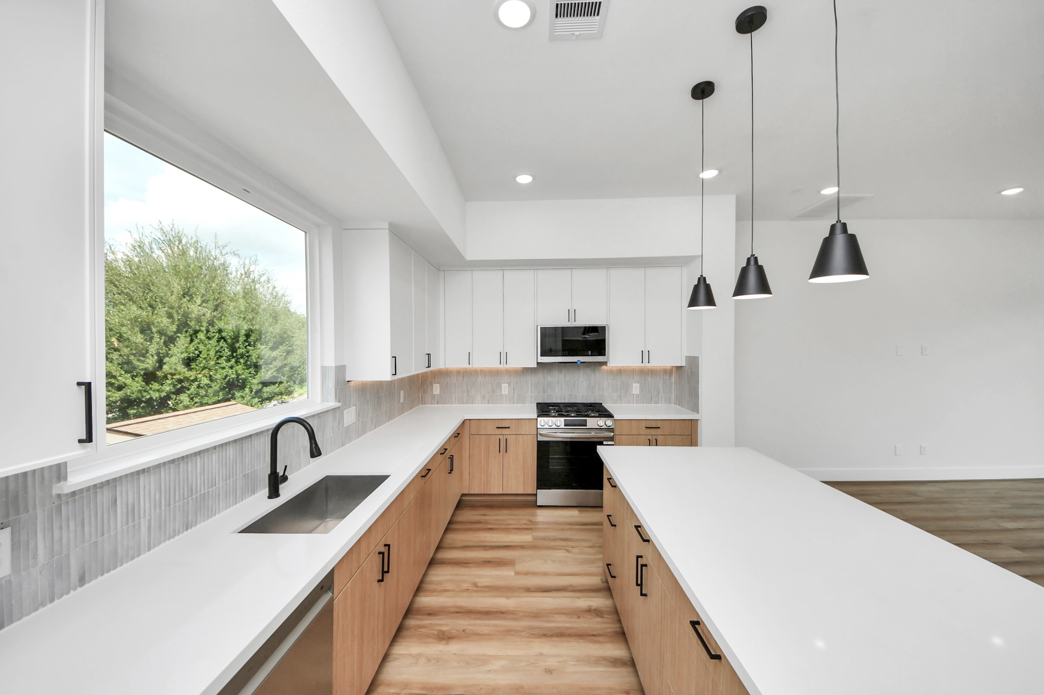6949 Foster Street Houston, TX 77021 - Photo 11 of 40 a large kitchen with kitchen island a large window a sink a counter space and stainless steel appliances
