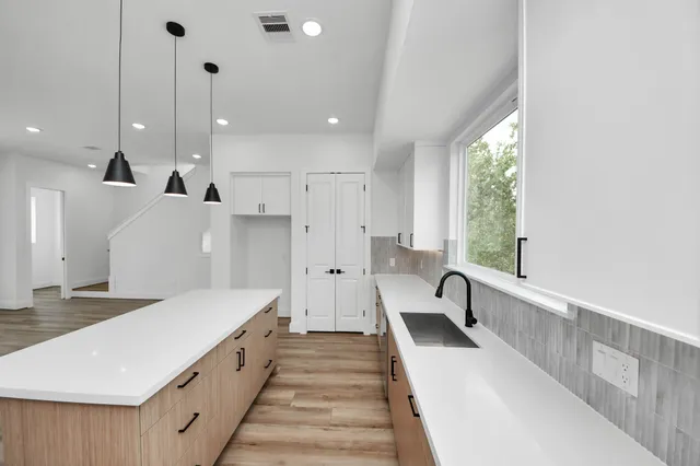 a large white kitchen with a large window