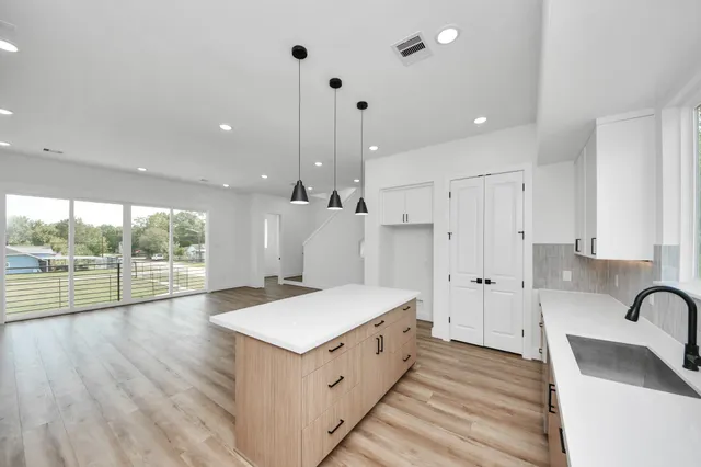 a large white kitchen with a large window