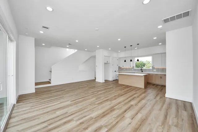 a view of a kitchen with kitchen island a sink stainless steel appliances and cabinets