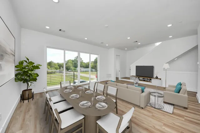 a living room with furniture a large window and a flat screen tv