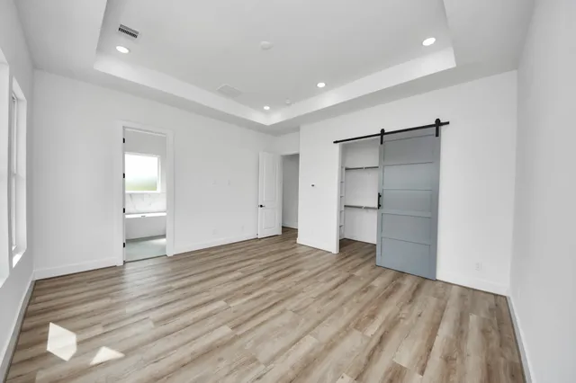 wooden floor in an empty room with a kitchen