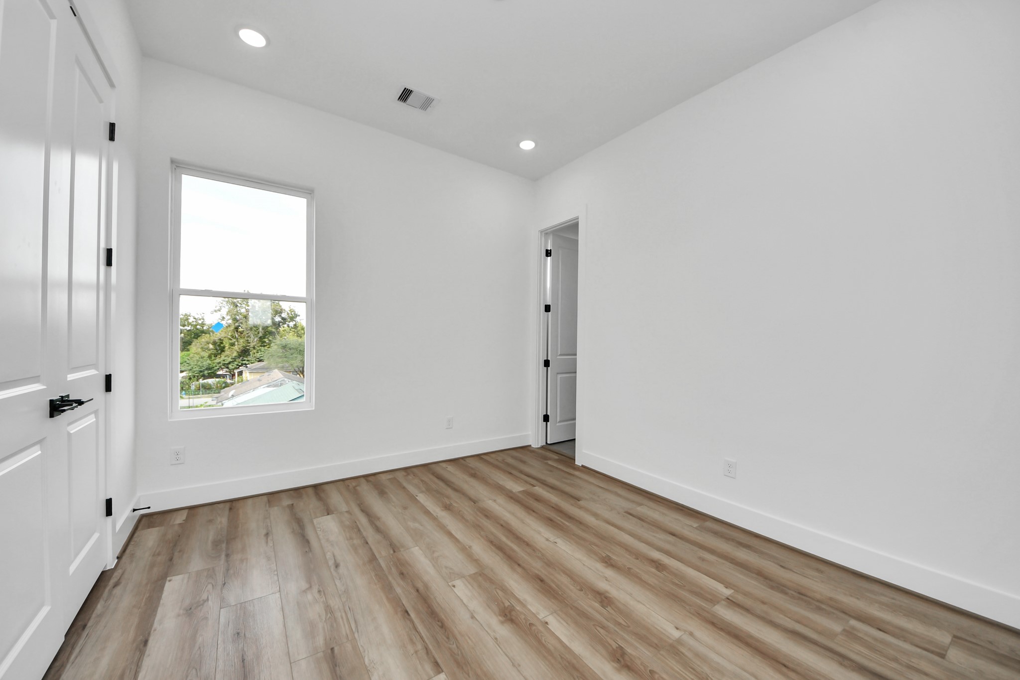 6949 Foster Street Houston, TX 77021 - Photo 31 of 40 an empty room with wooden floor and windows