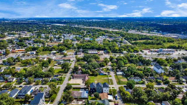 an aerial view of residential houses with outdoor space and trees