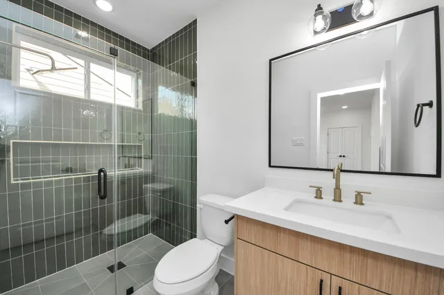 a bathroom with a sink a toilet and shower