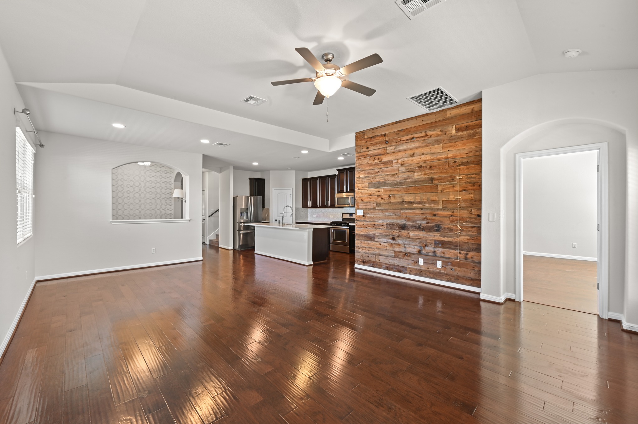 351 Wincliff Drive Buda, TX 78610 - Photo 16 of 40 Rich hardwood floors complement an accent wall of reclaimed wood, creating a warm, inviting living area.