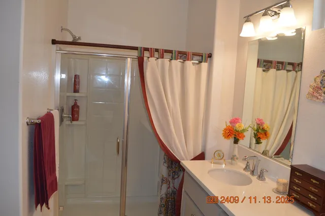 a bathroom with shower a sink and a mirror