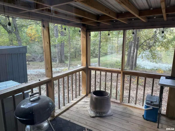 a view of a porch with furniture and wooden floor