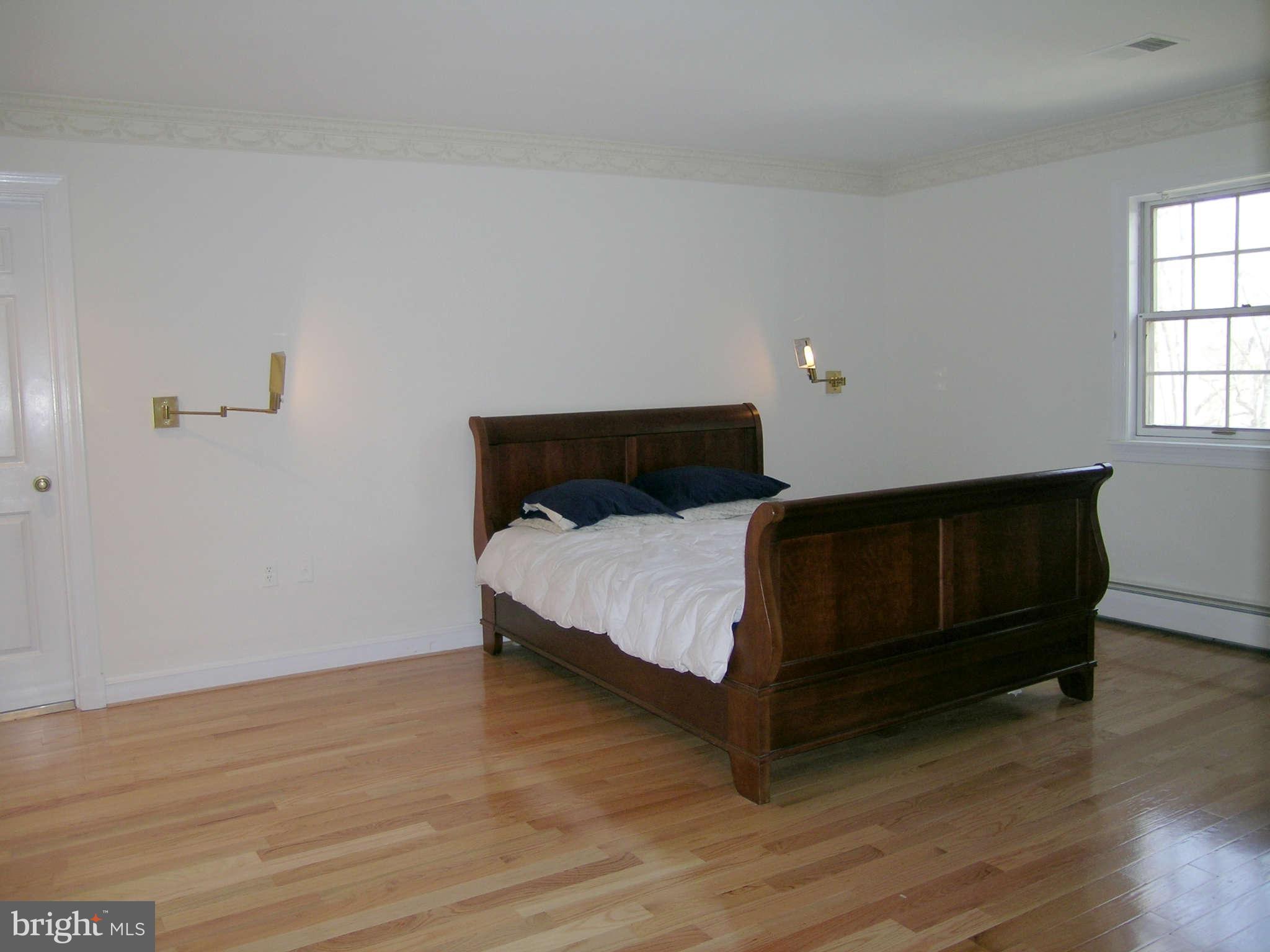 7570 Potomac Fall Road McLean, VA 22102 - Photo 12 of 20 a bed sitting in a bedroom next to a window with wooden floor