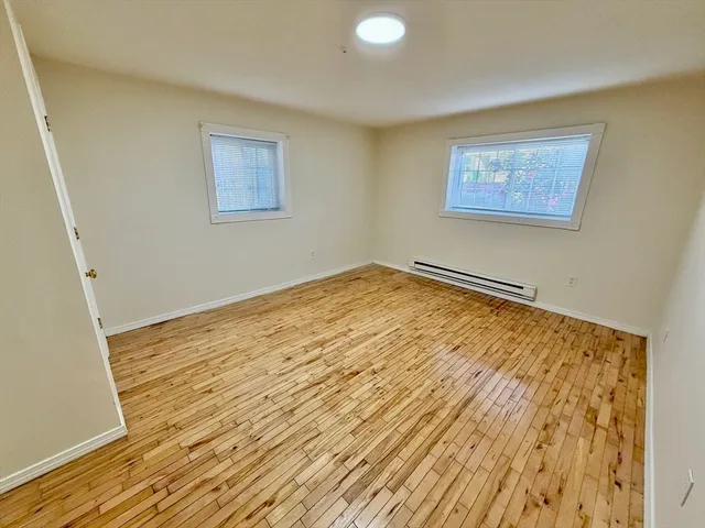 a view of empty room with wooden floor