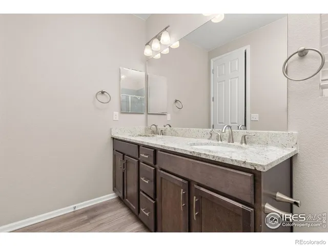 a bathroom with a granite countertop sink a light fixture and a mirror