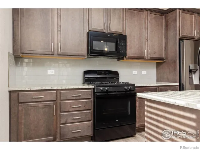 a kitchen with stainless steel appliances granite countertop a stove microwave and refrigerator