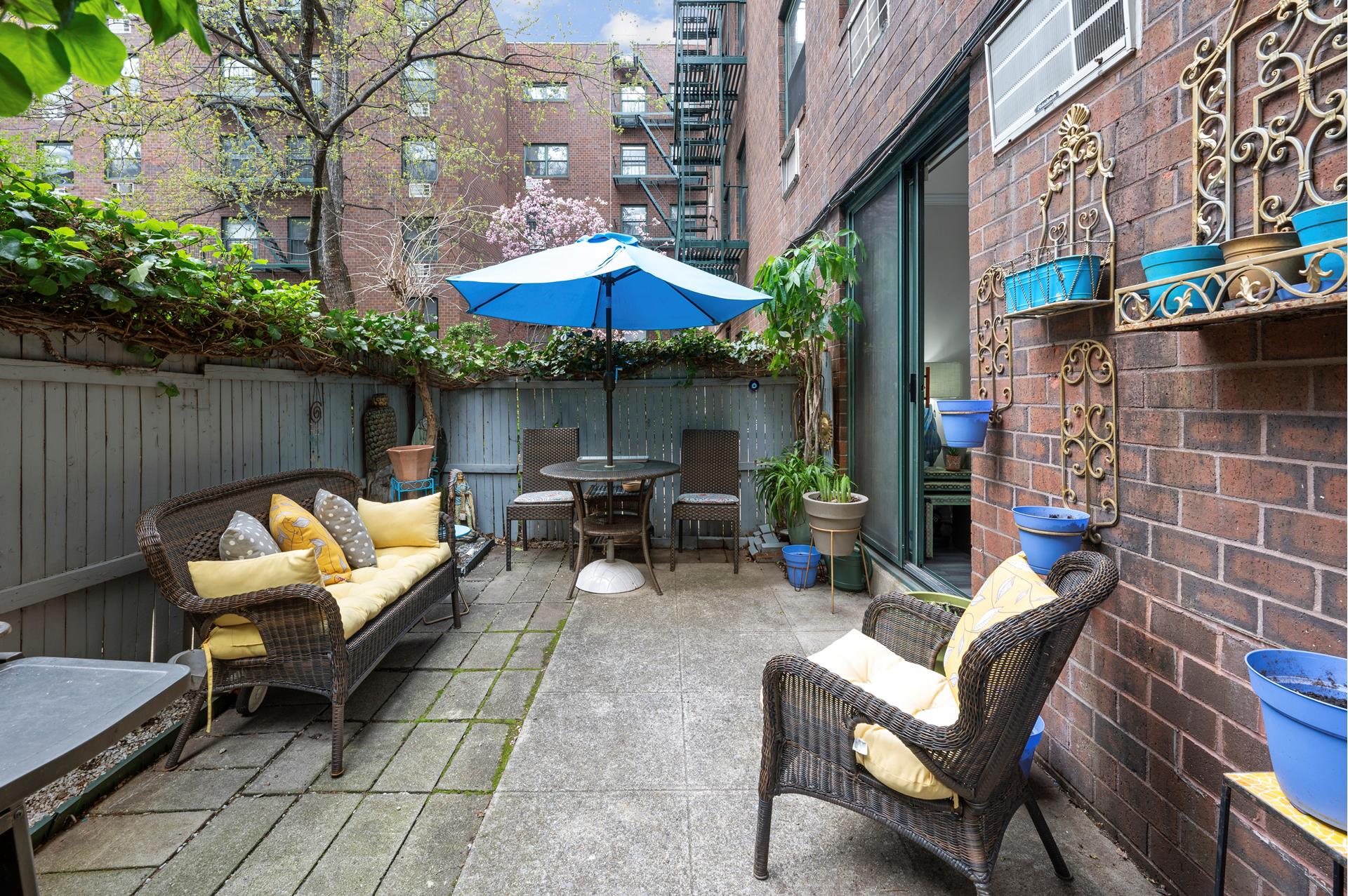 622 Washington Street, Unit GB Manhattan, NY 10014 - Photo 6 of 8 a backyard of a house with table and chairs