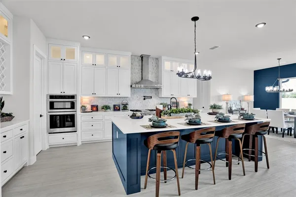 a kitchen with stainless steel appliances kitchen island a table and chairs in it