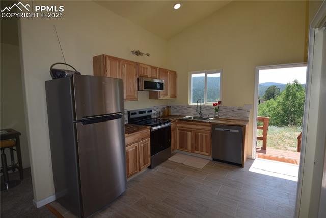 80 Spur Road Divide, CO 80814 - Photo 13 of 48 Kitchen with stainless steel appliances, tasteful backsplash, recessed lighting, and high vaulted ceiling