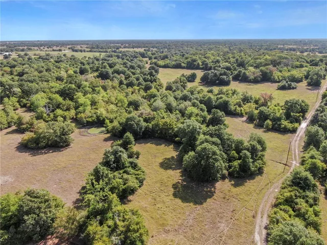 an aerial view of a houses with a yard and lake view