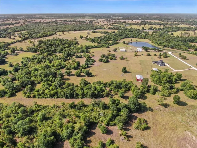an aerial view of a houses with a yard and lake view