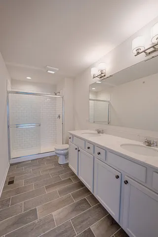 a spacious bathroom with a granite countertop sink a toilet and a tub