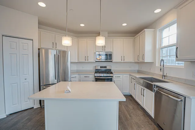 a kitchen with a sink a stove a refrigerator and a window