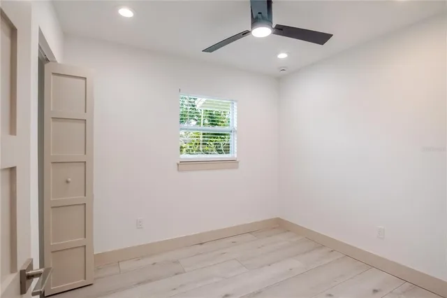 an empty room with a window and a ceiling fan