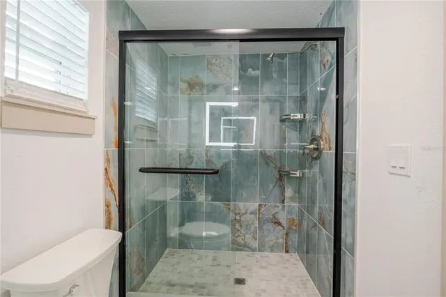 a bathroom with a glass shower door