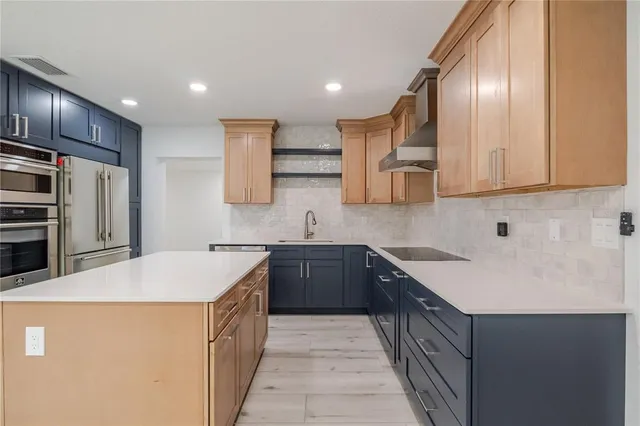 a kitchen with stainless steel appliances a sink stove and refrigerator