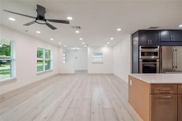 a view of kitchen with sink and refrigerator