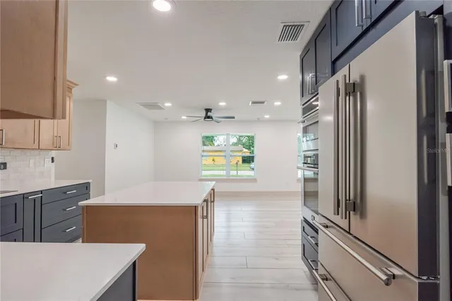 a kitchen with stainless steel appliances a refrigerator sink and stove