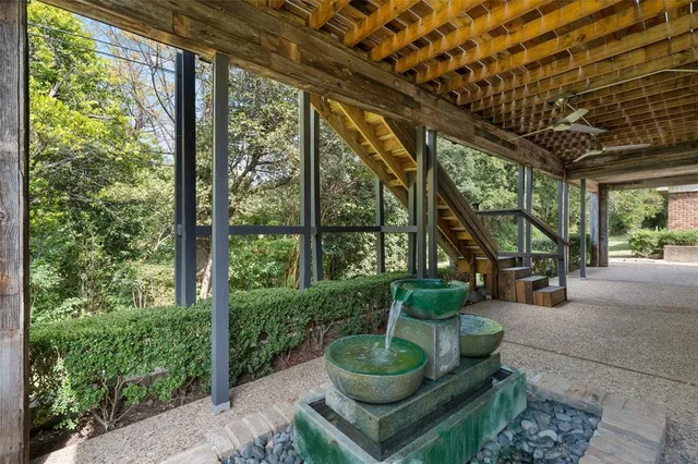 a living room with patio furniture and a potted plant