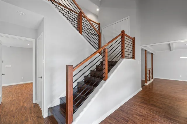 a view of a hallway with wooden floor and stairs