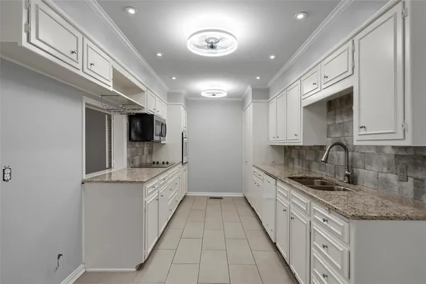 a large kitchen with stainless steel appliances granite countertop a sink and dishwasher a stove top oven with wooden floor