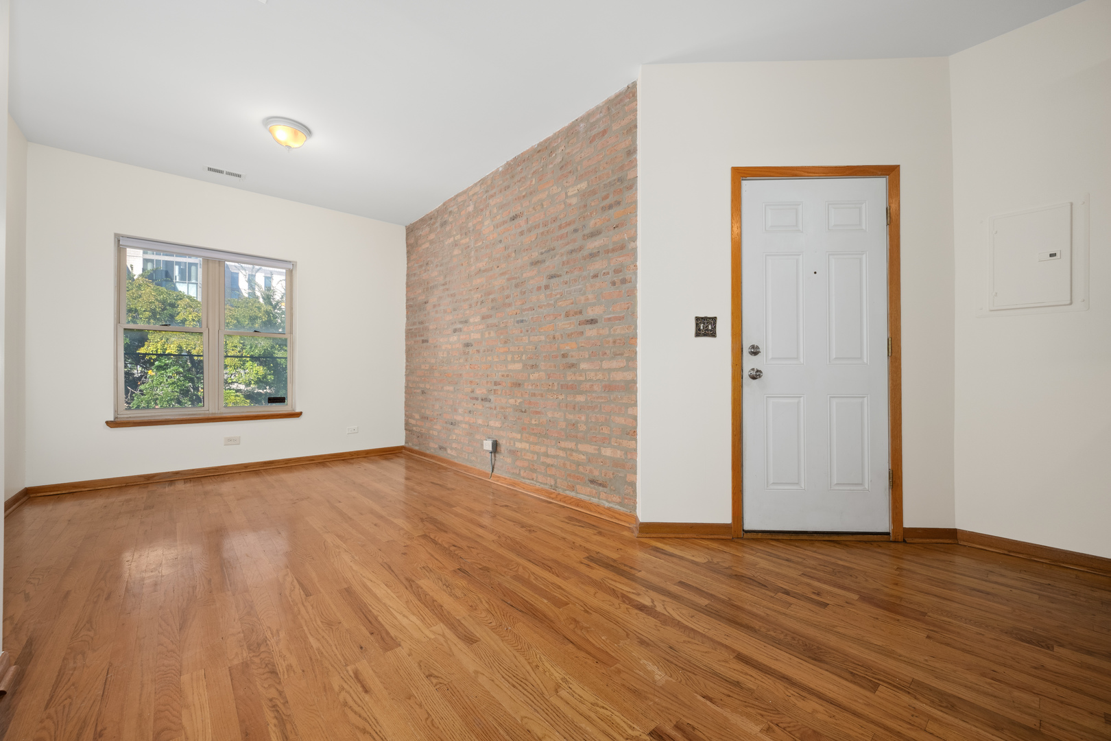 1167 East 61st Street, Unit 2 Chicago, IL 60637 - Photo 3 of 17 an empty room with wooden floor and windows