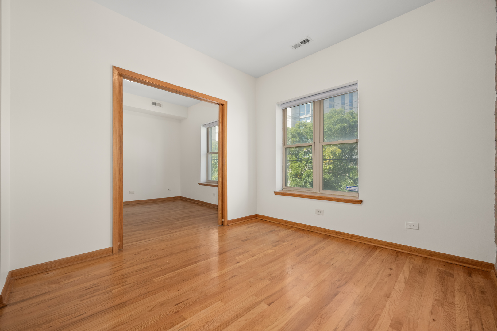 1167 East 61st Street, Unit 2 Chicago, IL 60637 - Photo 4 of 17 an empty room with wooden floor and windows