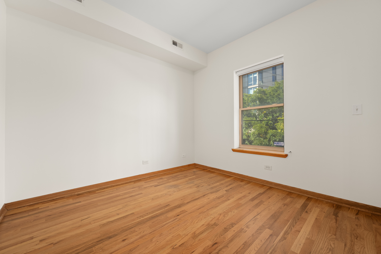 1167 East 61st Street, Unit 2 Chicago, IL 60637 - Photo 7 of 17 an empty room with wooden floor and windows