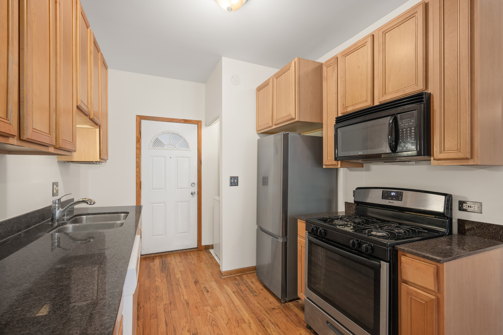 1167 East 61st Street, Unit 2 Chicago, IL 60637 - Photo 10 of 17 a kitchen with granite countertop a stove and a sink