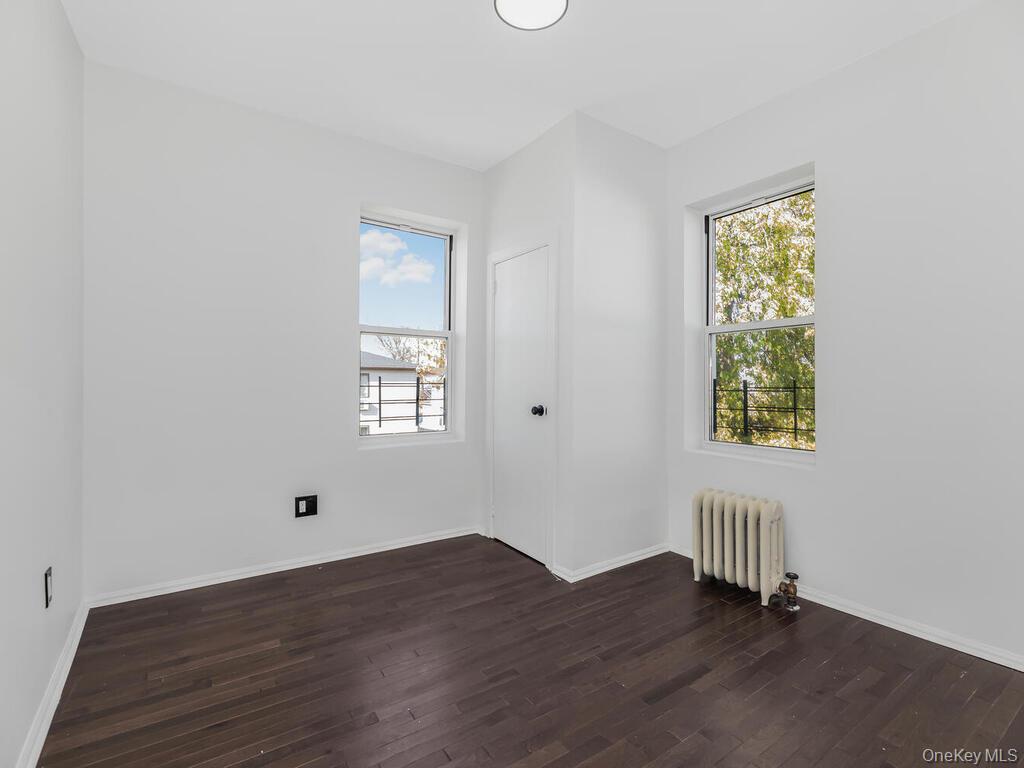 146-84 182nd Street Queens, NY 11413 - Photo 20 of 45 an empty room with wooden floor and windows