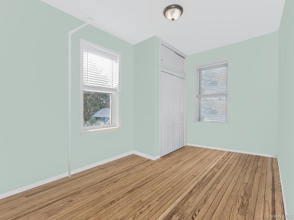 146-84 182nd Street Queens, NY 11413 - Photo 22 of 45 an empty room with wooden floor and windows