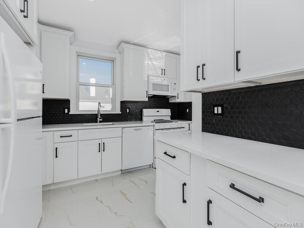 146-84 182nd Street Queens, NY 11413 - Photo 33 of 45 a kitchen with white cabinets and sink