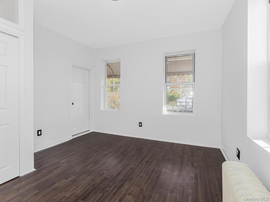 146-84 182nd Street Queens, NY 11413 - Photo 34 of 45 an empty room with wooden floor and windows