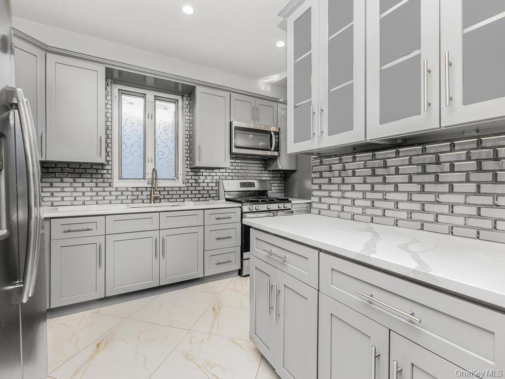 146-84 182nd Street Queens, NY 11413 - Photo 6 of 45 a kitchen with cabinets appliances a sink and a counter top space