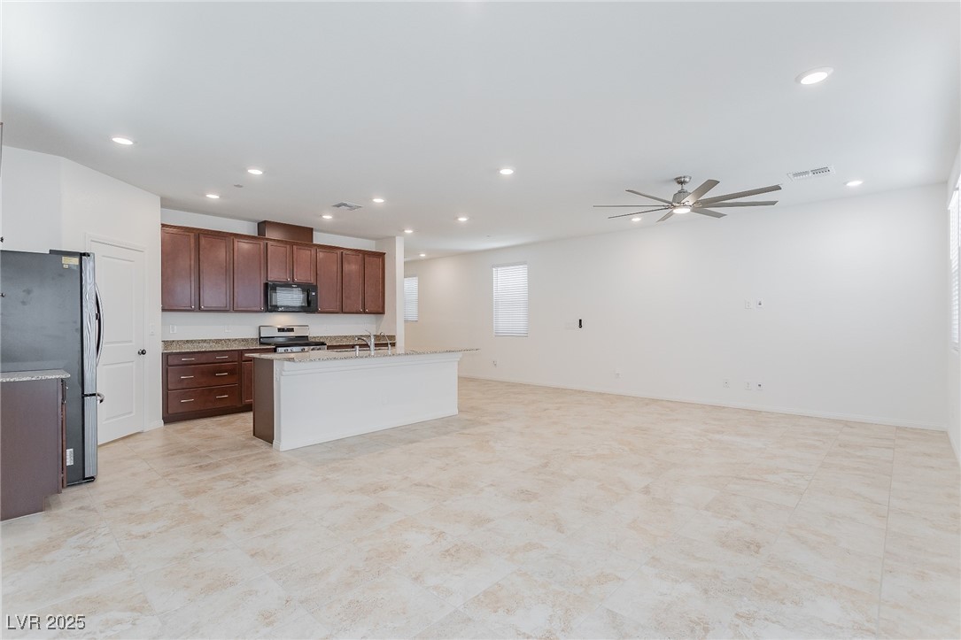 3468 Bradano Lane Henderson, NV 89044 - Photo 50 of 50 Kitchen with open floor plan, stainless steel appliances, a kitchen island with sink, recessed lighting, and light stone counters