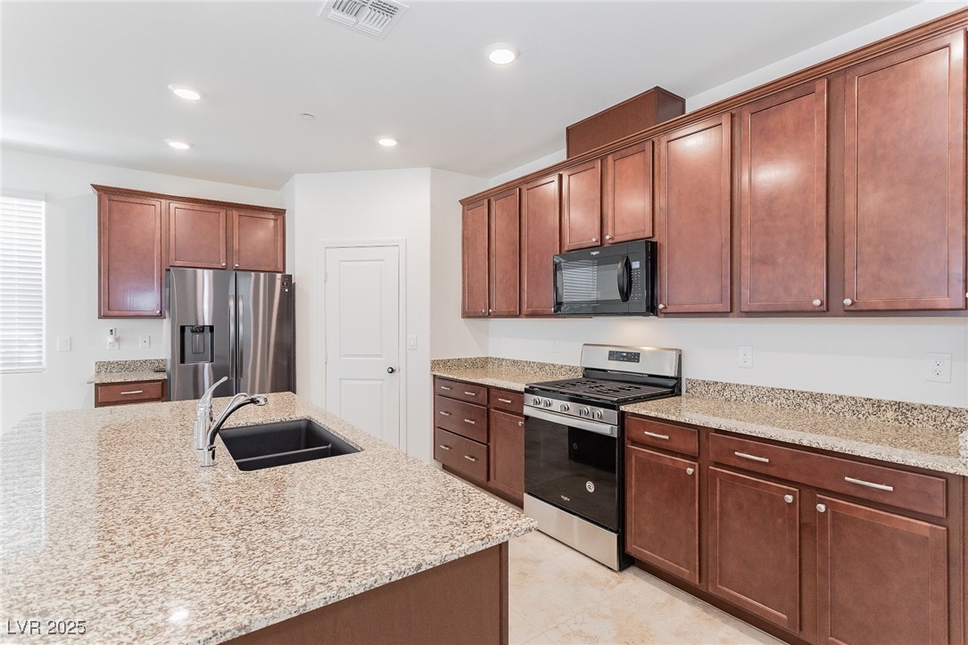 3468 Bradano Lane Henderson, NV 89044 - Photo 12 of 50 Kitchen featuring stainless steel appliances, light stone countertops, recessed lighting, and light tile patterned floors