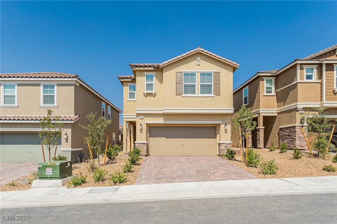 3468 Bradano Lane Henderson, NV 89044 - Photo 2 of 50 View of front of property featuring stone siding, stucco siding, decorative driveway, and an attached garage