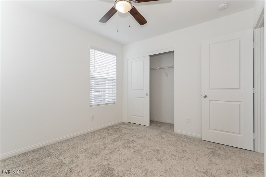 3468 Bradano Lane Henderson, NV 89044 - Photo 24 of 50 Unfurnished bedroom with light colored carpet, ceiling fan, and a closet