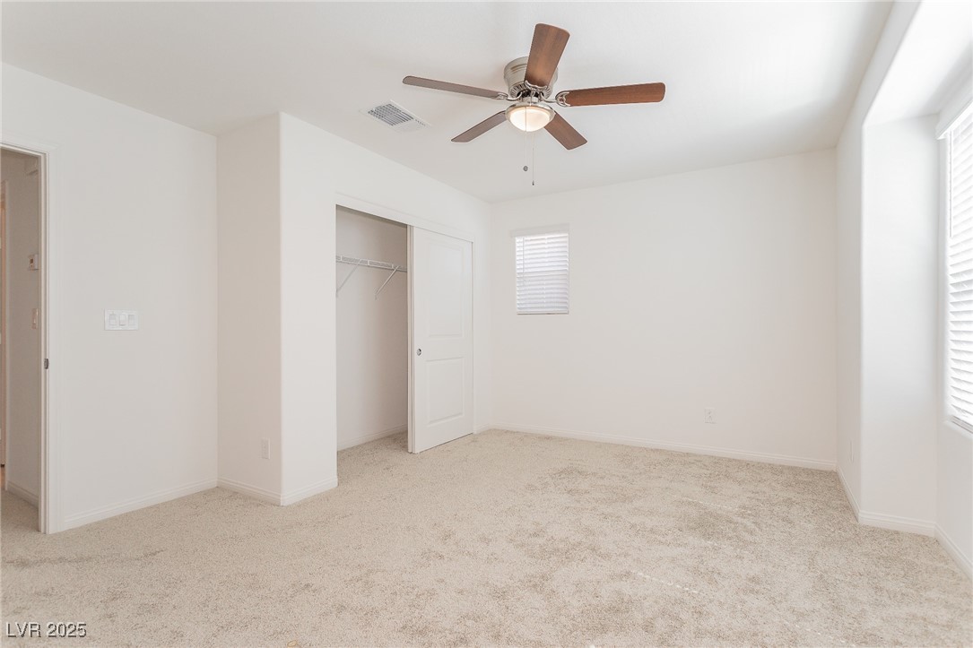 3468 Bradano Lane Henderson, NV 89044 - Photo 26 of 50 Unfurnished bedroom with light colored carpet, a closet, and a ceiling fan