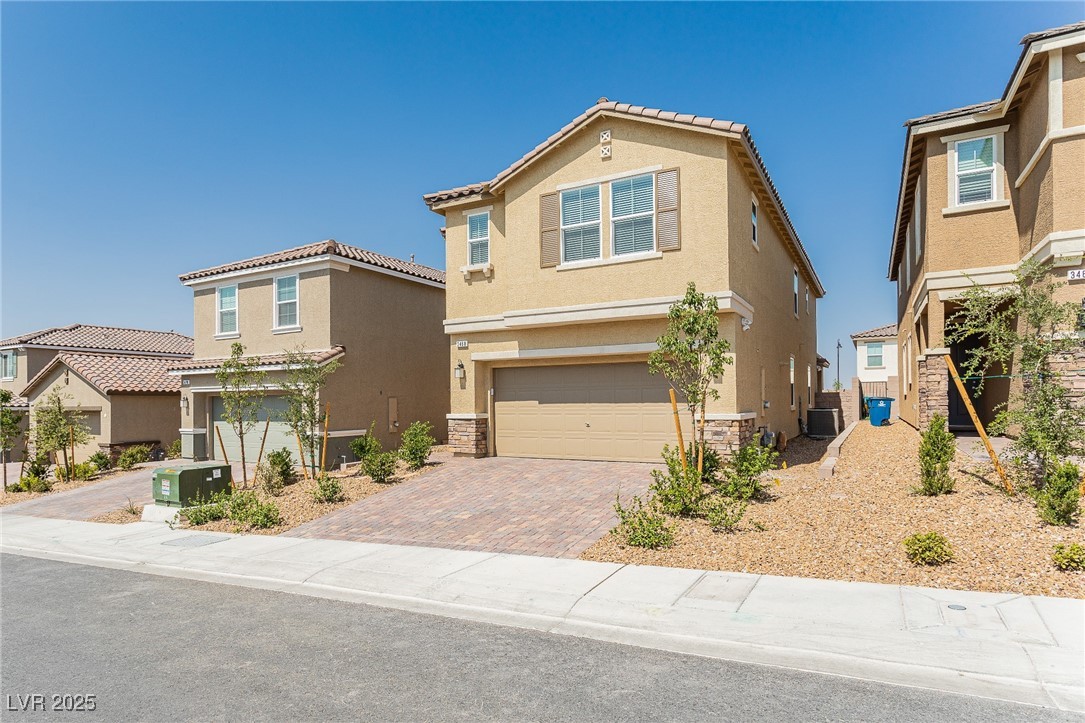 3468 Bradano Lane Henderson, NV 89044 - Photo 3 of 50 View of front facade featuring stucco siding, stone siding, decorative driveway, a garage, and a tile roof