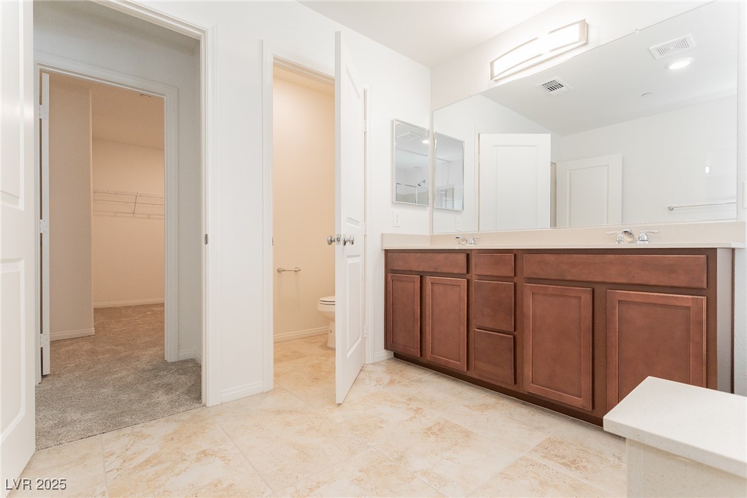 3468 Bradano Lane Henderson, NV 89044 - Photo 39 of 50 Full bath featuring double vanity, a spacious closet, and light colored carpet